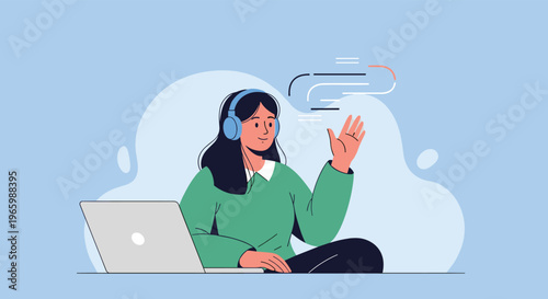 Young woman wearing blue headphones sitting at laptop and waving her hand during online video call with friendly smile.