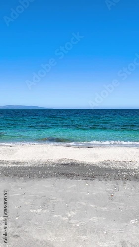 Vertical point of view walk on a white sand beach in Sardinia Approaching the turquoise sea the scene captures a relaxing Mediterranean coastal landscape 
