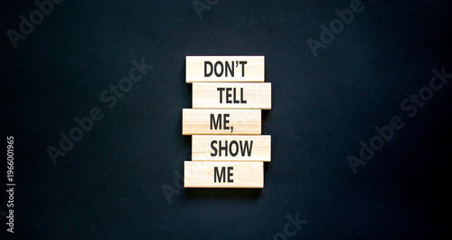 Tell or show symbol. Concept words Do not tell me, show me on beautiful wooden blocks. Beautiful black paper background. Business tell or show concept. Copy space.