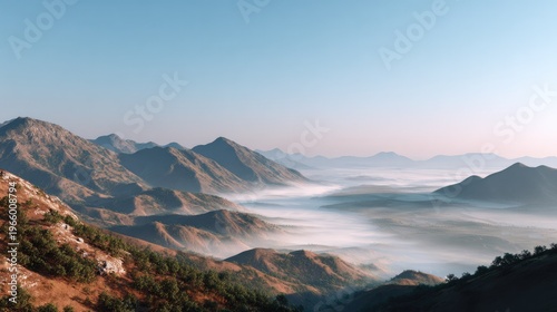 Majestic Mountain Vista: A sweeping panorama showcases rugged mountain peaks rising above a sea of clouds, basking in the soft glow of a clear sky, offering a breathtaking display of natural grandeur.