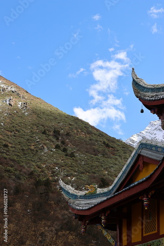 Ancient chinese flying eaves with ornate rooftops and bell of Huanglong Ancient Temple in Huanglong National Park, Songpan County, Sichuan Province of China