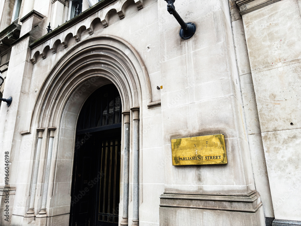 Fototapeta premium Historic Parliament Street building entrance with stone arch and brass plaque in London, UK