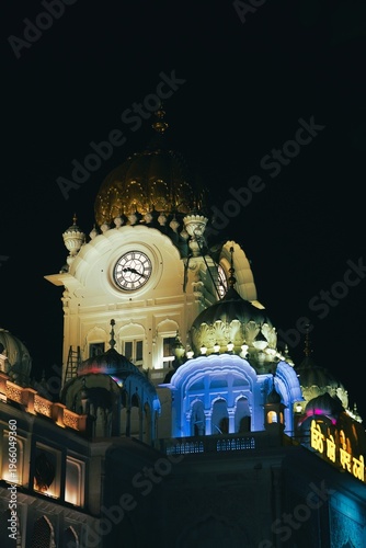 Close-Up View of Golden Temple Architecture with Clock Tower at Night