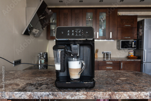 A coffee machine with a cup of cappuccino coffee on the kitchen counter. Front view.