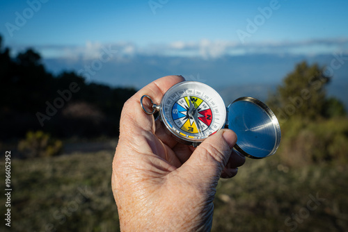 Принти на полотні Hand holding a compass for accurate navigation, guiding way during outdoor explo
