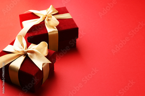 Beautiful velvet gift boxes on red background, closeup. Space for text