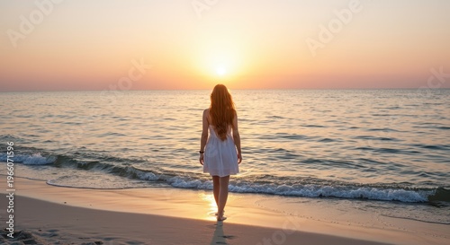 Young woman in white dress walks along the shore during brilliant ocean sunset
