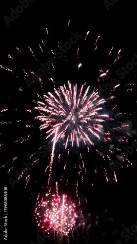 Real red shining fireworks lights in dark sky. Glowing fireworks show. New year's eve, national holiday, party or event fireworks celebration.