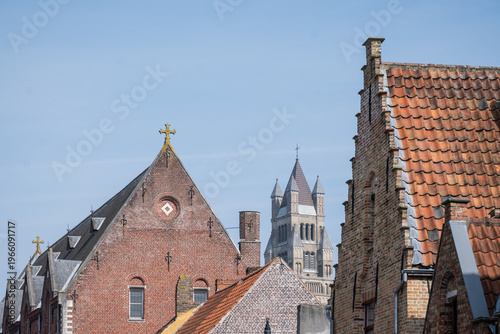 Bruges skyline with prominent gothic architecture tower st saviours cathedral above rooftop cityscape. Belgium Sint-Salvatorskathedraal popular tourist European culture destination sunny day blue sky