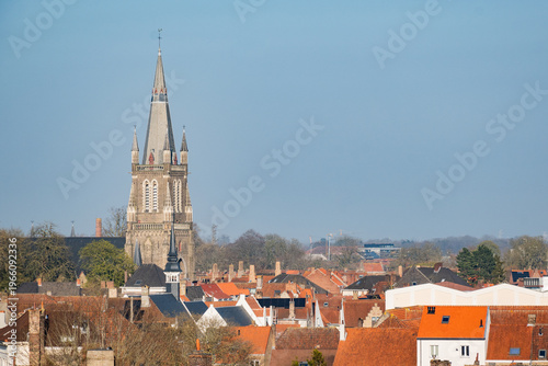 Bruges skyline with proinent gothic architecture tower church of our lady above rooftop cityscape. Belgium Onze Lieve Vrouwekerk popular tourist European culture destination sunny day blue sky