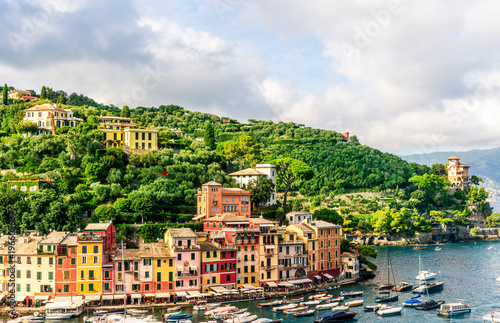 beautiful landscape of famous italiat resort Portofino in Luguria with ancient houses and buildings of hotels and restaulants along the embarkment of a sea gulf with sunset golden light