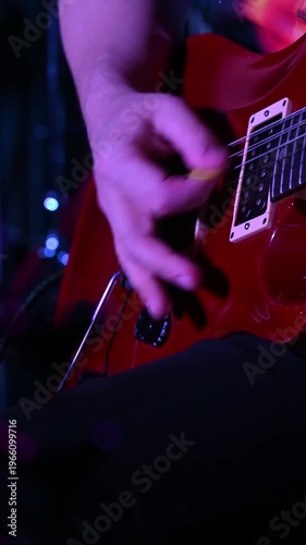 Close-up of a musician's hands playing an electric guitar. 