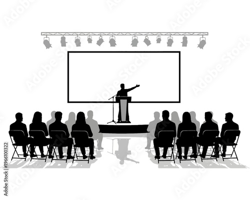 Silhouette of a speaker presenting information to an attentive seated audience under stage lighting