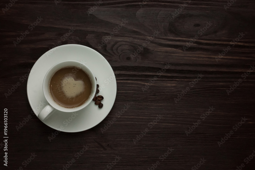 Fototapeta premium Top view of cappuccino with heart latte art and roasted coffee beans on dark textured background