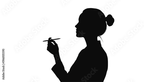 Profile silhouette of a woman holding a thin pen or stylus delicately between her fingers against a bright.