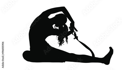 Silhouette of a person performs a deep seated forward bend stretching their leg with a strap assist.