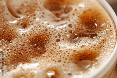 Iced oat milk latte with silky foam and cinnamon in cozy macro detail