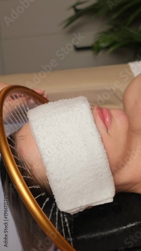 Young woman receiving a relaxing head massage and hair wash at a beauty salon