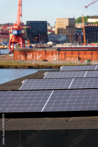 Solar panels on roof of apartment housing building with Gothenburg city center in background, Sweden, renewable green sustainable energy concept