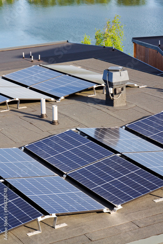 Solar panels on roof of apartment housing building with Gothenburg city center in background, Sweden, renewable green sustainable energy concept
