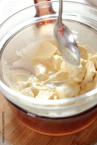 Melting white chocolate. Making frozen strawberry cheesecake series.