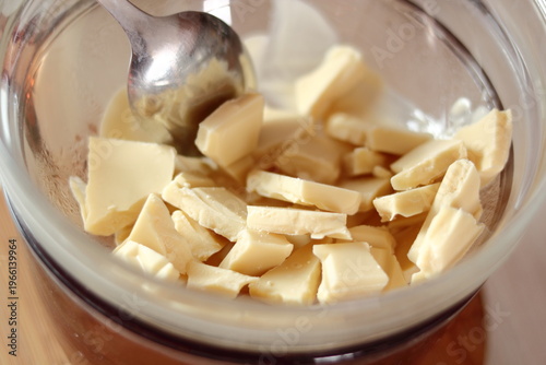 Melting white chocolate. Making frozen strawberry cheesecake series.