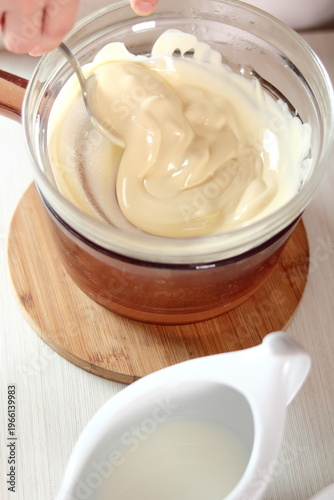 Melting white chocolate. Making frozen strawberry cheesecake series.