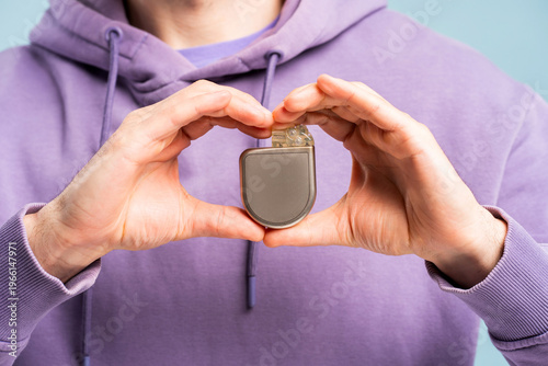 Foto Man holding cardiac pacemaker, showing device for heart rhythm control selective