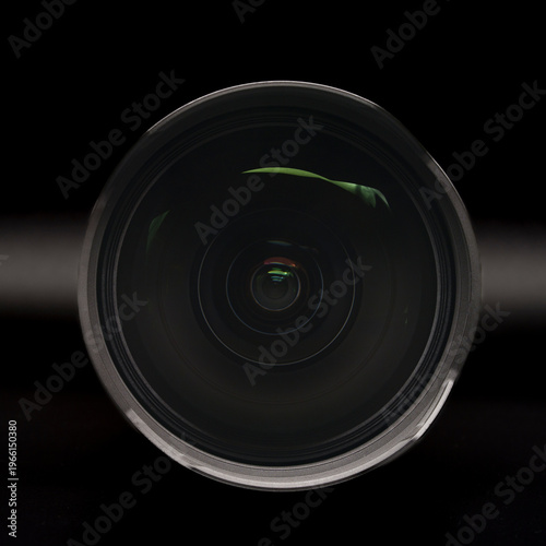 Huge front element of a 12-24 ultra wide-angle zoom lens on a black background