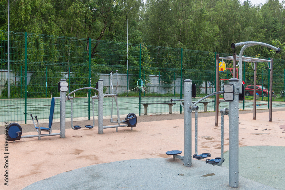 Fototapeta premium Modern outdoor gym in urban park with fitness equipment and green surroundings