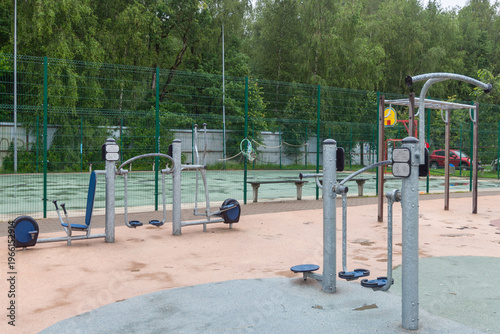 Modern outdoor gym in urban park with fitness equipment and green surroundings