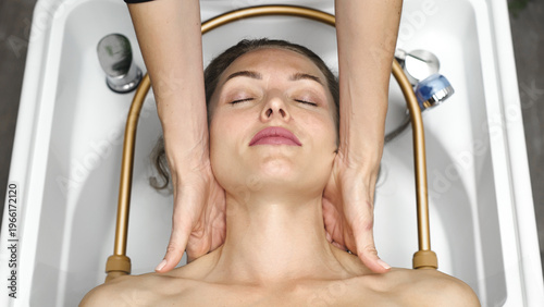 Close up of relaxing facial massage therapy performed by professional in spa.
