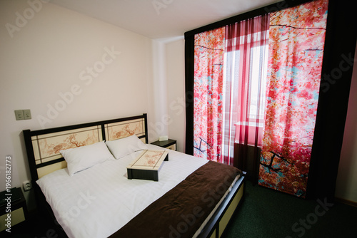 Astrakhan, Russia - September 18, 2015: Modern bedroom with floral curtains and double bed