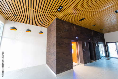Modern interior design of lobby with wooden ceiling and elevator access