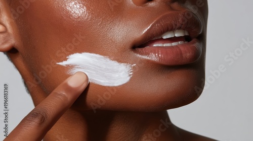Close-up of a woman's face applying cream for healthy, glowing skin