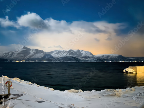 Mestervik, Norway - December 29, 2025: Malangen Brygger Resort. Glowing yellow light on the horizon in the evening cloudscape