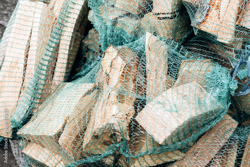 Pile of firewood logs wrapped in green netting