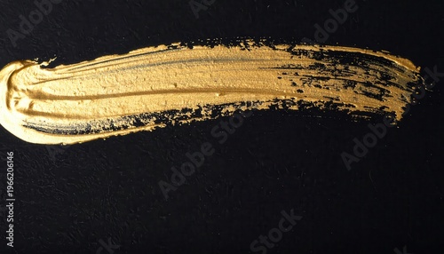 Pennellata orizzontale di vernice oro metallizzato brillante su sfondo nero profondo, texture astratta.