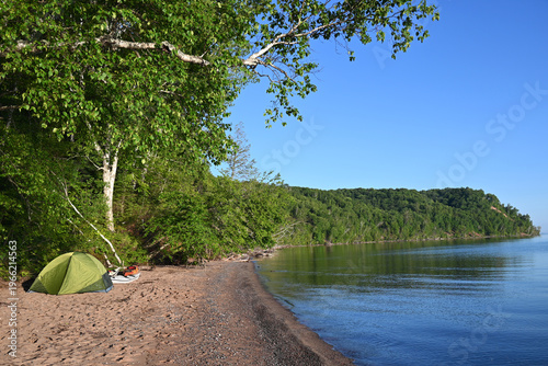 A campsite with tent and kayaks set up on an isolated beach along Lake Superior in the Apostle Islands National Lakeshore in northern Wisconsin.