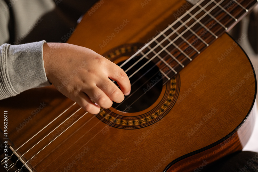 Fototapeta premium Hand strumming classical guitar strings learning music