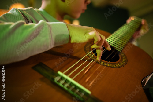 Tableau sur toile Boy learning playing classical guitar at home