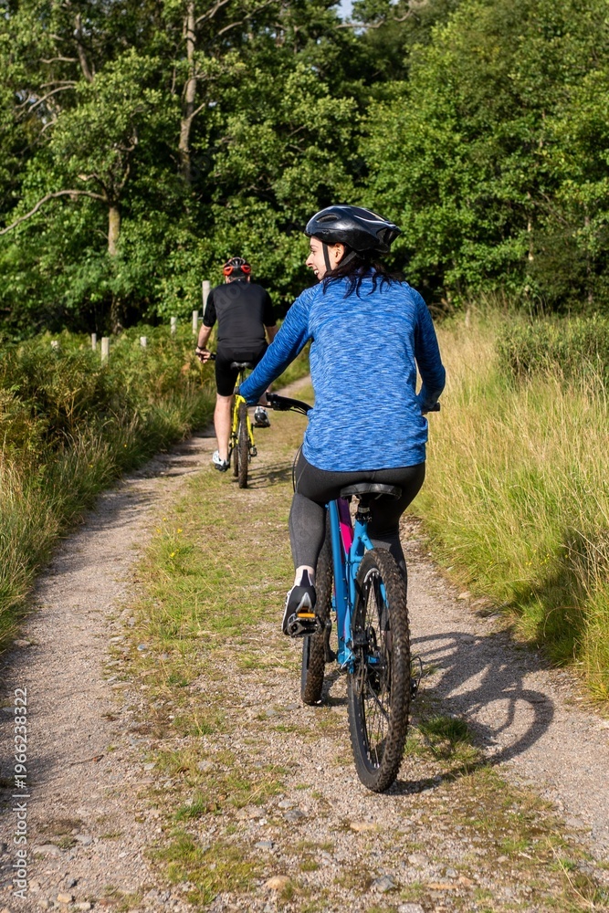Fototapeta premium Cyclists enjoying scenic forest trail.