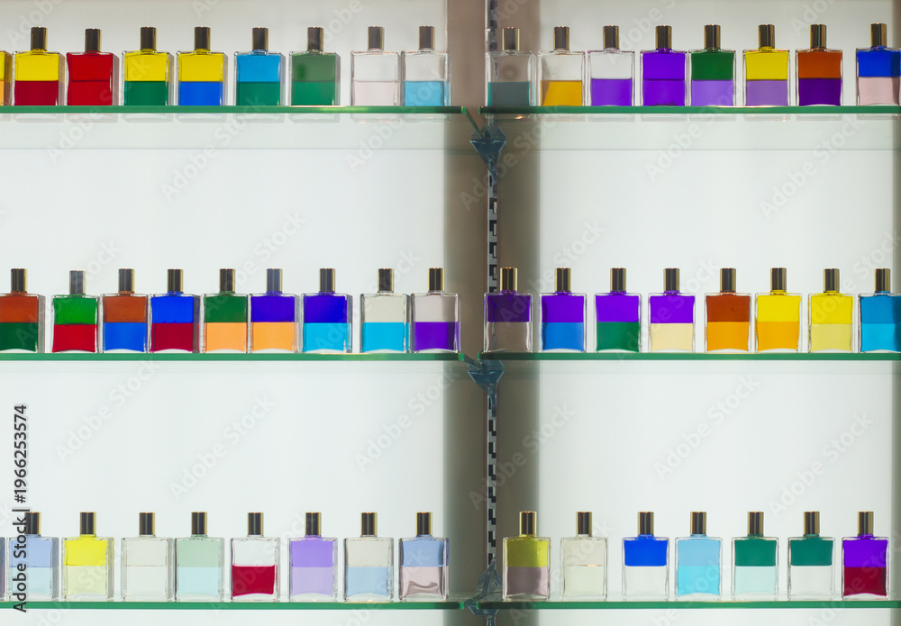 Fototapeta premium Colorful dual-layered liquid bottles on glass display shelves