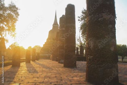Canvas Print Ancient stone columns and stupa at sunset in Sukhothai Historical Park