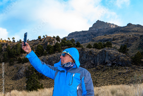 Man hiking iztaccihuatl volcano taking selfie with phone