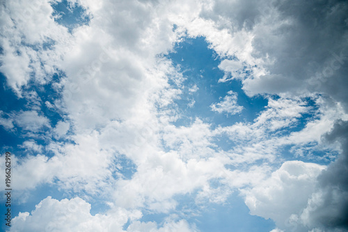 View of  bright blue sky filled with various cloud formations.  soft white cumulus and dramatic grey clouds , beautiful and natural atmospheric background.