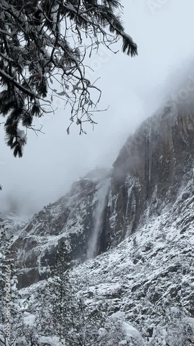 snowstorm and foggy morning over Yosemite valley and Bridalveil Falls in the distance on a winter day in Yosemite National Park, California