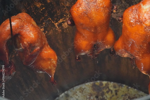 Wallpaper Mural Roasted ducks, also known as bebek, hang from hooks in a kitchen in Indonesia, showcasing a traditional cooking method with a focus on the crispy, golden-brown skin. Torontodigital.ca