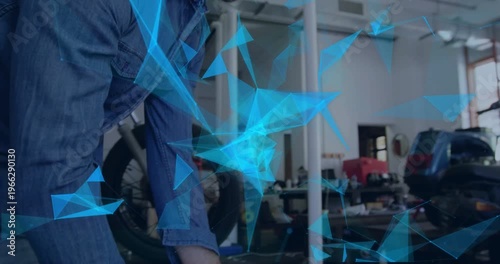 Tech placing tire starting fit check checking tread leaning inspecting bike under blue mesh for fit