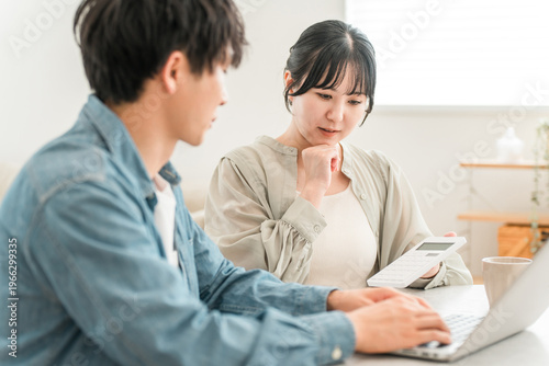 Slika na platnu A young Asian couple struggling with household finances due to rising prices (de